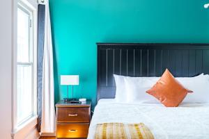 a bedroom with a bed with a blue wall at Jungle House Columbus Downtown Free Parking Sleeps 8 - Walk to Convention Center & Nationwide Arena - 2BR Short North Luxury Home - Over 5,800 Five Star Stays in Columbus