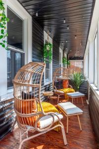 a porch with two rocking chairs and windows at Jungle House Columbus Downtown Free Parking Sleeps 8 - Walk to Convention Center & Nationwide Arena - 2BR Short North Luxury Home - Over 5,800 Five Star Stays in Columbus