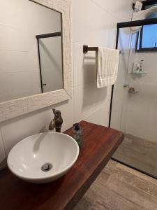 un bagno con un lavandino bianco e uno specchio di Refugio do Capivari a Represa Capivari