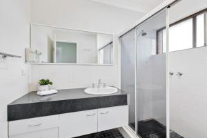 un bagno bianco con lavandino e doccia di Beachside Escape with Resort Facilities Sandcastles 226 a Coffs Harbour