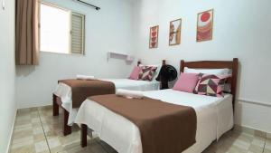 een kamer met drie bedden en een raam bij Doce Recanto da re in Franca