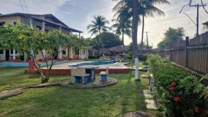 un patio trasero con mesa de picnic y piscina en Pousada Encantos de Paripueira, en Paripueira 10 fotos más