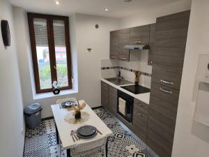 a small kitchen with a table and a sink at Cozy Studio avec Parking Charleville in Charleville-Mézières