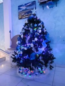 a blue christmas tree with lights on it at Stabia Dream Rooms in Castellammare di Stabia