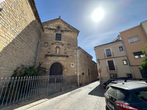 乌贝达Hovalis Sites, The Showroom的一栋老旧的砖砌建筑，带有一个大门，停着几辆车。