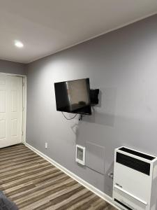 ein Wohnzimmer mit einem Flachbildfernseher an der Wand in der Unterkunft By The Way Motel Lake Bluff in Lake Bluff