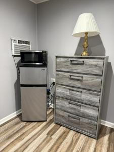 eine Küche mit Mikrowelle und einer Kommode mit Lampe in der Unterkunft By The Way Motel Lake Bluff in Lake Bluff