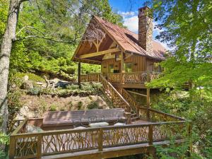 Una gran casa de madera con un puente que conduce a ella. en River Sound Cabin at Eagles Nest, en Banner Elk