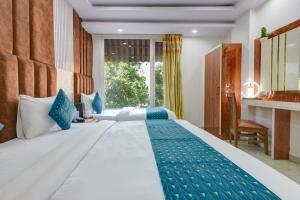 a bedroom with a large white bed with blue accents at Hotel Ambience in New Delhi +96 photos