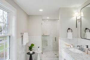 a white bathroom with a shower and a sink at Explore Cleveland Attractions! Family-Focused Home in Beachwood +24 photos