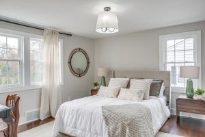 a bedroom with a white bed with a mirror and windows at Explore Cleveland Attractions! Family-Focused Home in Beachwood