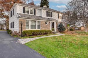 a white house with a driveway in front of it at Explore Cleveland Attractions! Family-Focused Home in Beachwood