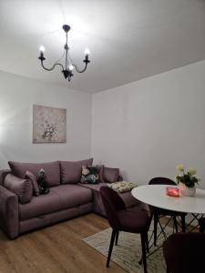 a living room with a couch and a table at Koviljača apartman Demetrios in Banja Koviljača