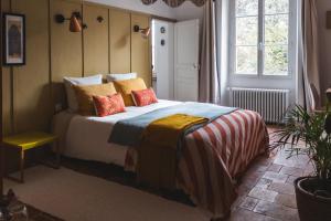 MontrevaultMaison d'hôtes La bien-Aimée的一间卧室配有带色彩缤纷枕头的床