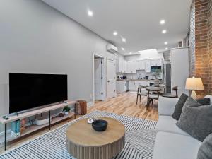 een woonkamer met een bank en een tv bij The Brick Treasury Loft in Cleveland