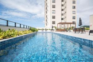 a swimming pool on the side of a building at Apto Penha a 300M PRAIA 8 min do BETO CARREIRO com PISICNA, sacada com CHURRASQUEIRA privativa, AR CONDICIONADO Wi Fi, PORTARIA 24h,vaga privativa de GARAGEM in Penha