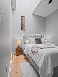 een witte slaapkamer met een groot bed en een houten vloer bij The Brick Treasury Loft in Cleveland