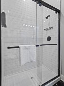 een douche met een glazen deur en een handdoek bij The Brick Treasury Loft in Cleveland +85 foto's