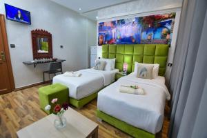 una habitación de hotel con dos camas y un sofá en Hotel Dar Annasr, en Chefchaouen 14 fotos más