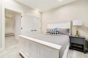 a white bedroom with a large white bed in it at Jungle House Luxury Homes - Columbus Downtown Short North - Near Convention Center & Nationwide Arena - Sleeps up to 16 - Free Parking - Over 5,800 Five Stars in Columbus +21 photos