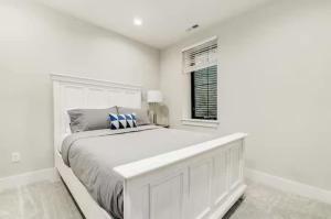a white bedroom with a large bed and a window at Jungle House Luxury Homes - Columbus Downtown Short North - Near Convention Center & Nationwide Arena - Sleeps up to 16 - Free Parking - Over 5,800 Five Stars in Columbus