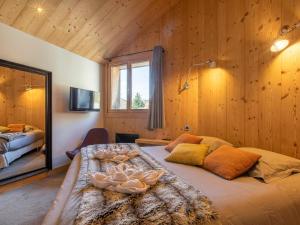 モルジヌにあるChalet moderne 16 pers. au cœur d'Avoriaz avec sauna - FR-1-314-95の木の壁の部屋にある大きなベッド