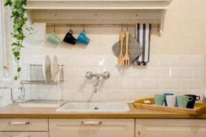 a kitchen counter with a sink and utensils at Il Leoncino Loft con vista sulla Piazza in Pistoia