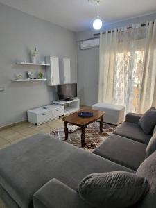 una sala de estar con un sofá y una mesa en Apartamente Noel Vlore, en Vlorë