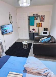 uma sala de estar com um sofá e uma TV em YouShelter em Londres