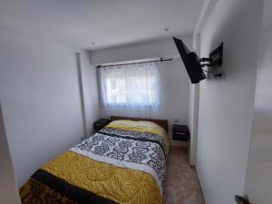a small bedroom with a bed and a window at Sol y Luna Hospedajes 3 in San Bernardo