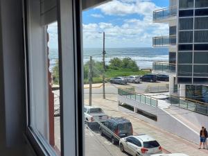 a view of the ocean from a window of a building at Sol y Luna Hospedajes 3 in San Bernardo