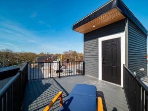 een dek met een blauwe bank en een zwarte deur bij The Brick Treasury Loft in Cleveland