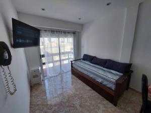 a bedroom with a bed with a television and a phone at Sol y Luna Hospedajes 3 in San Bernardo