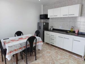 a kitchen with a table and chairs and a refrigerator at Sol y Luna Hospedajes 3 in San Bernardo