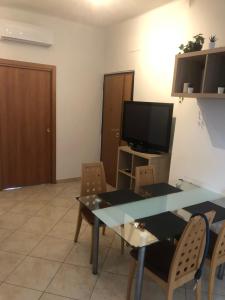 a living room with a table and chairs and a television at Dimora CentoDue in Bari