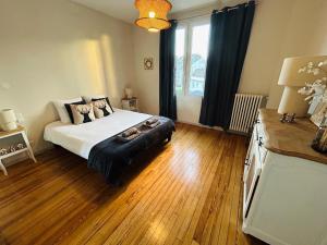 a bedroom with a bed and a large window at Le 5 - Spacieux 2 pièces Caen Centre Le Port in Caen