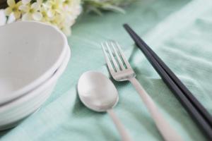 a table with a fork and spoon on a table at b hotel Wanoyado Kanayama - Entire House Stay Japanese Style with 2 Baths in Hiroshima