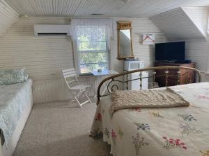 a bedroom with a bed and a chair and a window at Mountain Harbour B&B in Roan Mountain
