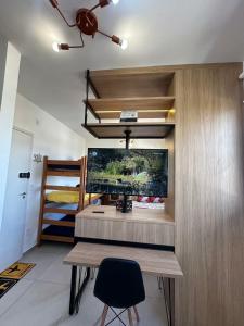 a room with a desk and a large screen tv at TESLA APT2-Pool, Air, gym, 24-hour portaria in São Carlos