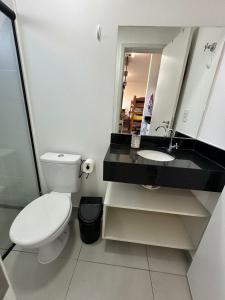 a bathroom with a toilet and a sink and a mirror at TESLA APT2-Pool, Air, gym, 24-hour portaria in São Carlos