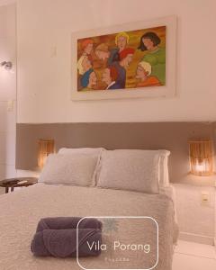 un dipinto sopra un letto in una camera da letto di Vila Porang Pousada a São Miguel dos Milagres