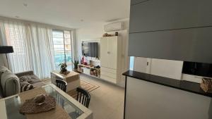 a kitchen and a living room with a table at Punta del Este, Sol y Luna II, Departamento 301 in Punta del Este