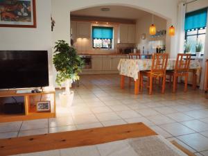 a kitchen and dining room with a table and a tv at Villa Julia 148 in Callantsoog
