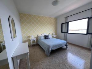 ein Schlafzimmer mit einem Bett und einem Fenster in der Unterkunft casa el lajiar in Orzola