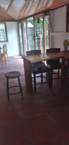 RivasにあるRustic two bedroom house right by the Chirripo riverの木製のテーブルと椅子のあるダイニングルーム