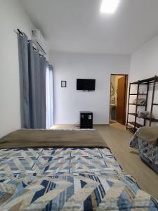 a bedroom with a bed and a tv on the wall at Pousada Espaço Vista Mar in Itanhaém