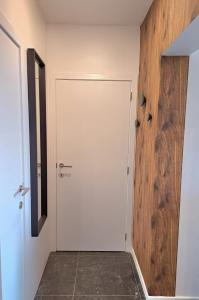 a white door in a room with a wooden wall at L'Escapade Tournaisienne in Tournai