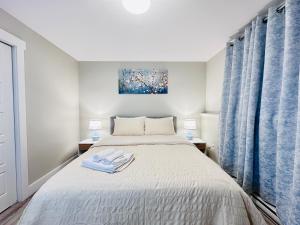 una camera da letto con un letto con due lampade e tende blu di Moon's Suite near the New Hospital a Corner Brook
