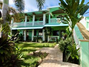 大玉米岛Hospedaje Rosa Del Mar & Sweets Cafe的一栋前面有棕榈树的房子