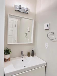 un bagno bianco con lavandino e specchio di Moon's Suite near the New Hospital a Corner Brook
